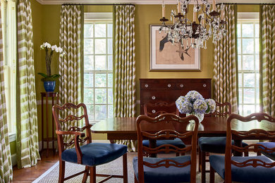 Example of a classic dark wood floor and brown floor enclosed dining room design in Charlotte with green walls