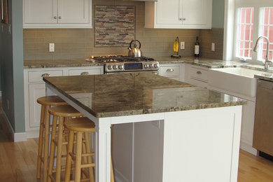 Mid-sized farmhouse l-shaped light wood floor open concept kitchen photo in Boston with a farmhouse sink, beaded inset cabinets, white cabinets, granite countertops, brown backsplash, glass tile backsplash, stainless steel appliances and an island
