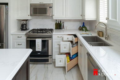 Inspiration for a medium sized traditional l-shaped kitchen/diner in Toronto with a double-bowl sink, shaker cabinets, white cabinets, engineered stone countertops, white splashback, stone slab splashback, stainless steel appliances, porcelain flooring, an island, white floors and white worktops.