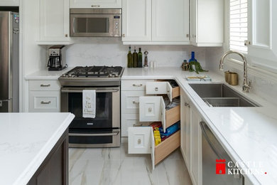 Eat-in kitchen - mid-sized transitional l-shaped porcelain tile and white floor eat-in kitchen idea in Toronto with a double-bowl sink, shaker cabinets, white cabinets, quartz countertops, white backsplash, stone slab backsplash, stainless steel appliances, an island and white countertops