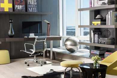 Inspiration for a mid-sized contemporary study room in Boston with grey walls, light hardwood floors and a built-in desk.