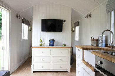 Design ideas for a small country open plan living room in Other with white walls, light hardwood flooring and brown floors.