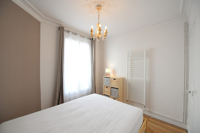 Réalisation d'une petite chambre parentale design avec un mur blanc, parquet clair, aucune cheminée et un sol marron.