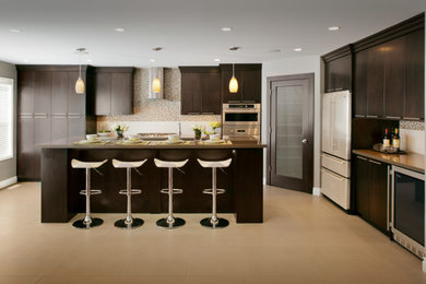Example of a mid-sized trendy l-shaped ceramic tile eat-in kitchen design in Calgary with an undermount sink, flat-panel cabinets, dark wood cabinets, solid surface countertops, white backsplash, subway tile backsplash, stainless steel appliances and an island