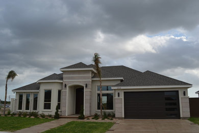 Inspiration for a mid-sized transitional white one-story stucco house exterior remodel in Austin with a hip roof and a shingle roof