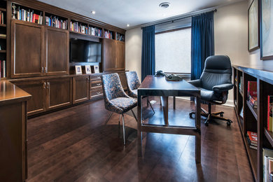 Mid-sized transitional freestanding desk dark wood floor study room photo in Toronto with gray walls