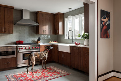 Eat-in kitchen - small transitional l-shaped eat-in kitchen idea in Burlington with a farmhouse sink, flat-panel cabinets, dark wood cabinets, quartz countertops, glass tile backsplash, stainless steel appliances, no island and white countertops