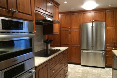 Example of a mid-sized transitional linoleum floor kitchen design in Seattle with an undermount sink, raised-panel cabinets, medium tone wood cabinets, quartzite countertops, beige backsplash, ceramic backsplash and stainless steel appliances