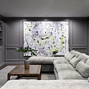 Expansive classic fully buried basement in New York with grey walls, dark hardwood flooring, a ribbon fireplace and a metal fireplace surround.
