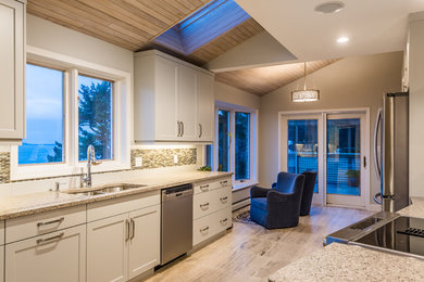 Example of a mid-sized transitional galley eat-in kitchen design with a double-bowl sink, beaded inset cabinets, gray cabinets, quartz countertops, multicolored backsplash, mosaic tile backsplash, stainless steel appliances and a peninsula