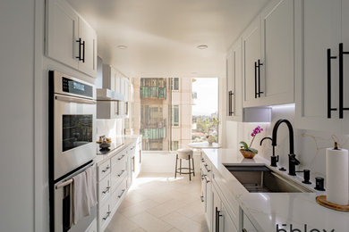 Mid-sized transitional galley ceramic tile and white floor kitchen photo in Los Angeles with shaker cabinets, white cabinets, quartz countertops, multicolored backsplash, quartz backsplash, stainless steel appliances, no island and multicolored countertops