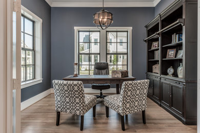 Mid-sized transitional freestanding desk medium tone wood floor and brown floor study room photo in Houston with gray walls