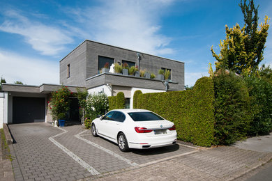 Expansive contemporary two-storey grey house exterior in Dortmund with wood siding and a flat roof.