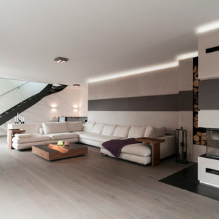 Inspiration för ett stort funkis allrum med öppen planlösning, med ett finrum, vita väggar, ljust trägolv, en dubbelsidig öppen spis och en spiselkrans i gips