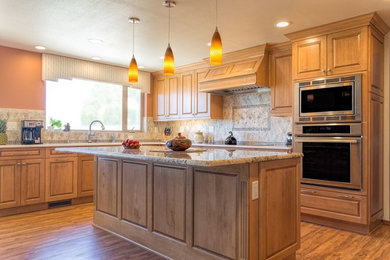 Large elegant u-shaped light wood floor eat-in kitchen photo in Orange County with a double-bowl sink, raised-panel cabinets, light wood cabinets, granite countertops, gray backsplash, ceramic backsplash, stainless steel appliances and an island