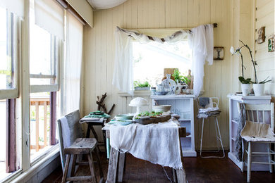 Inspiration for a shabby-chic style dining room in Sydney with yellow walls and dark hardwood floors.