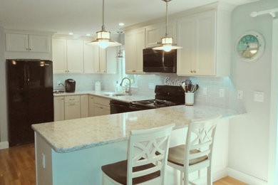 Eat-in kitchen - small transitional u-shaped medium tone wood floor and brown floor eat-in kitchen idea in Boston with a double-bowl sink, recessed-panel cabinets, white cabinets, quartzite countertops, gray backsplash, subway tile backsplash, black appliances, a peninsula and white countertops