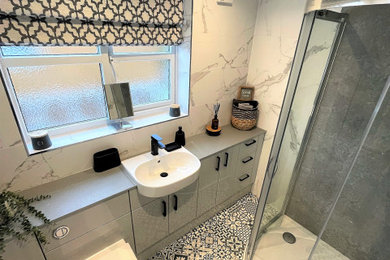 This is an example of a medium sized modern family bathroom in Other with flat-panel cabinets, grey cabinets, a corner shower, a one-piece toilet, white tiles, porcelain tiles, porcelain flooring, a built-in sink, multi-coloured floors, a sliding door, grey worktops, a single sink and a built in vanity unit.