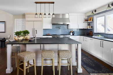 Inspiration for a mid-sized transitional l-shaped medium tone wood floor and brown floor open concept kitchen remodel in Denver with an undermount sink, flat-panel cabinets, white cabinets, soapstone countertops, blue backsplash, ceramic backsplash, paneled appliances, an island and black countertops