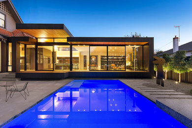 Photo of a mid-sized contemporary backyard rectangular lap pool in Melbourne with concrete slab.
