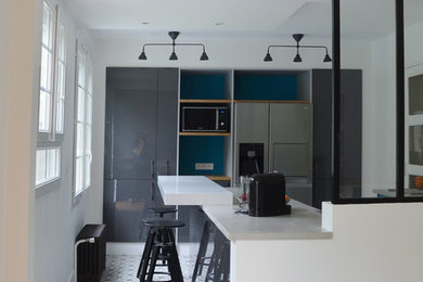 Photo of a mid-sized contemporary galley open plan kitchen in Paris with concrete benchtops and ceramic floors.