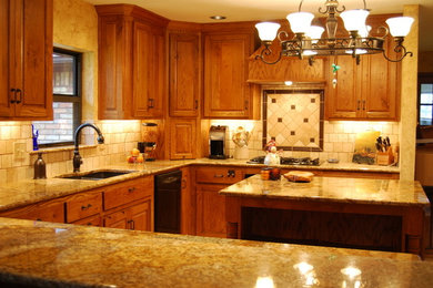 Inspiration for a mid-sized rustic u-shaped ceramic tile eat-in kitchen remodel in Dallas with a double-bowl sink, raised-panel cabinets, medium tone wood cabinets, granite countertops, beige backsplash, stone tile backsplash, black appliances and an island