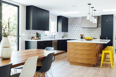 Design ideas for a modern l-shaped eat-in kitchen in Dallas with a drop-in sink, flat-panel cabinets, black cabinets, laminate benchtops, white splashback, ceramic splashback, stainless steel appliances, light hardwood floors, with island, beige floor and white benchtop.