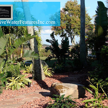 Tropical backyard room with pool waterfall, fireplace, and koi pond
