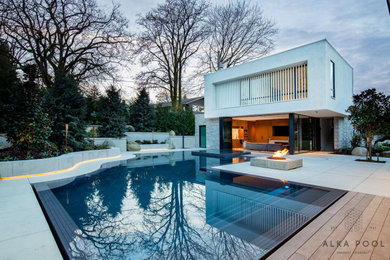 This is an example of a contemporary backyard custom-shaped pool in Vancouver with a hot tub and concrete pavers.