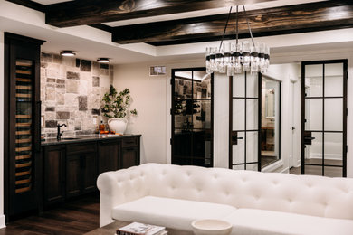 Example of a mid-sized mountain style underground dark wood floor, brown floor, exposed beam and wall paneling basement design in Detroit with a bar and white walls