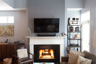 Inspiration for a mid-sized transitional formal and enclosed medium tone wood floor living room remodel in Chicago with blue walls, a standard fireplace, a concrete fireplace and a wall-mounted tv
