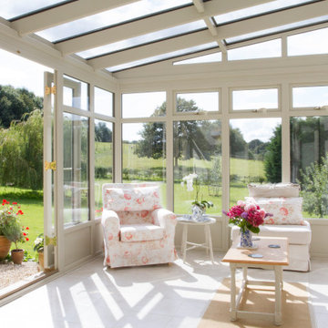Bespoke white timber lean-to conservatory extension on a quintessential country