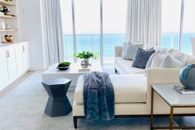 Example of a mid-sized beach style formal and open concept medium tone wood floor and brown floor living room design in Miami with white walls and a media wall