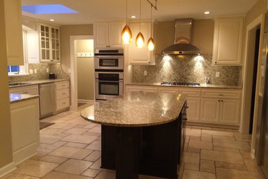 Inspiration for a timeless travertine floor and beige floor kitchen remodel in San Diego with raised-panel cabinets, white cabinets, granite countertops, stone slab backsplash, stainless steel appliances and an island
