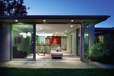 This is an example of a mid-sized contemporary open concept family room in Los Angeles with green walls and slate floors.