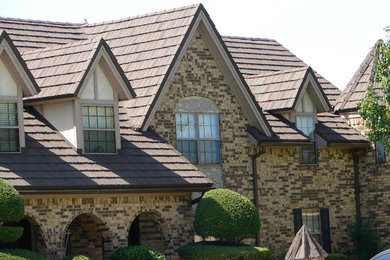 This is an example of a mid-sized traditional two-storey brick brown house exterior in Dallas with a gable roof and a shingle roof.