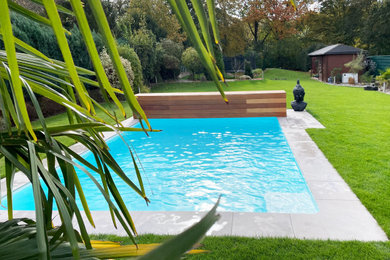 Moderner Pool neben dem Haus in rechteckiger Form mit Pool-Gartenbau und Natursteinplatten in Sonstige