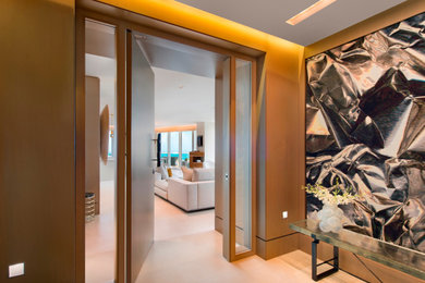 Small eclectic limestone floor, tray ceiling and wall paneling entryway photo in Miami with a medium wood front door