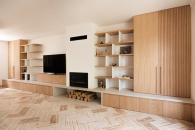 Idée de décoration pour un salon blanc et bois nordique de taille moyenne et fermé avec une bibliothèque ou un coin lecture, un mur beige, un sol en travertin, un poêle à bois, un manteau de cheminée en plâtre, un téléviseur encastré, un sol beige, un plafond à caissons et éclairage.