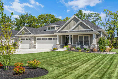Inspiration for a large transitional gray one-story stone and board and batten house exterior remodel in Other with a hip roof, a mixed material roof and a gray roof