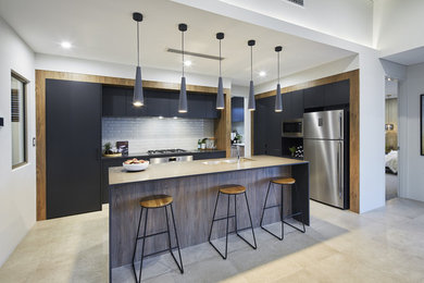 This is an example of a contemporary single-wall kitchen in Perth with an undermount sink, flat-panel cabinets, white splashback, subway tile splashback, stainless steel appliances, with island, beige floor, black benchtop, grey cabinets and quartz benchtops.