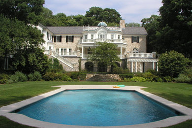 Design ideas for a traditional backyard custom-shaped pool in New York with natural stone pavers.