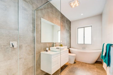 Diseño de cuarto de baño minimalista con baldosas y/o azulejos blancos, baldosas y/o azulejos de cerámica, suelo de baldosas de porcelana y suelo gris