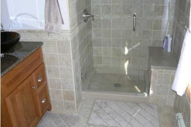Example of a small classic master beige tile and porcelain tile porcelain tile alcove shower design in Portland Maine with a vessel sink, furniture-like cabinets, medium tone wood cabinets, granite countertops and beige walls