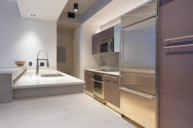 Inspiration for a mid-sized contemporary galley kitchen in Miami with a double-bowl sink, flat-panel cabinets, brown cabinets, concrete benchtops, grey splashback, stainless steel appliances, light hardwood floors and a peninsula.