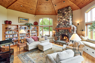 Design ideas for a country living room in Other with beige walls, medium hardwood floors, a standard fireplace, a stone fireplace surround, brown floor, exposed beam and wood.