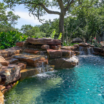 Rustic freeform with Boulder Wall Waterfalls and Spa