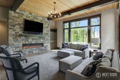 Inspiration for a large rustic formal and open concept living room remodel in Grand Rapids with gray walls, a stone fireplace and a wall-mounted tv