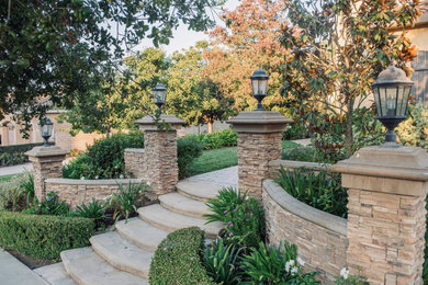 Design ideas for a mid-sized mediterranean full sun front yard concrete paver and metal fence landscaping in Los Angeles for summer.