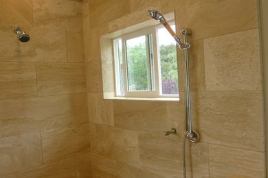 Inspiration for a bathroom in San Francisco with a corner shower, beige tile and stone tile.
